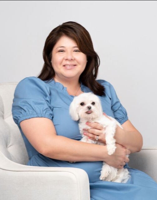 Picture of Liz Boyle smiling holding dog.